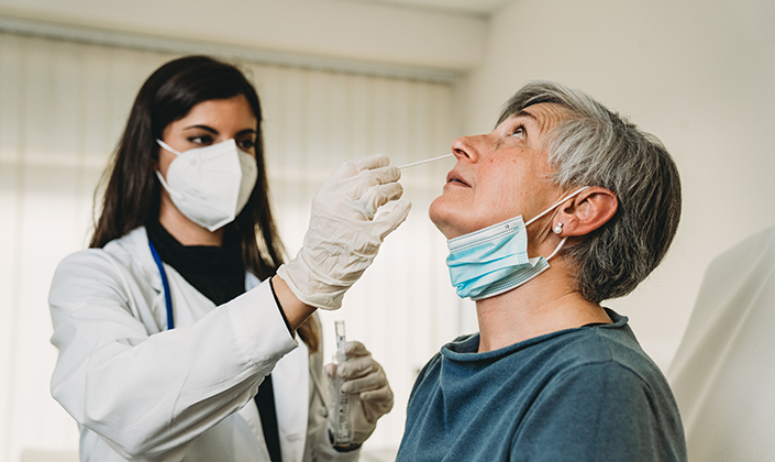 Medizinische Fachperson nimmt &#228;lterer Patientin Probe aus dem Nasen-Rachenraum f&#252;r Coronatest